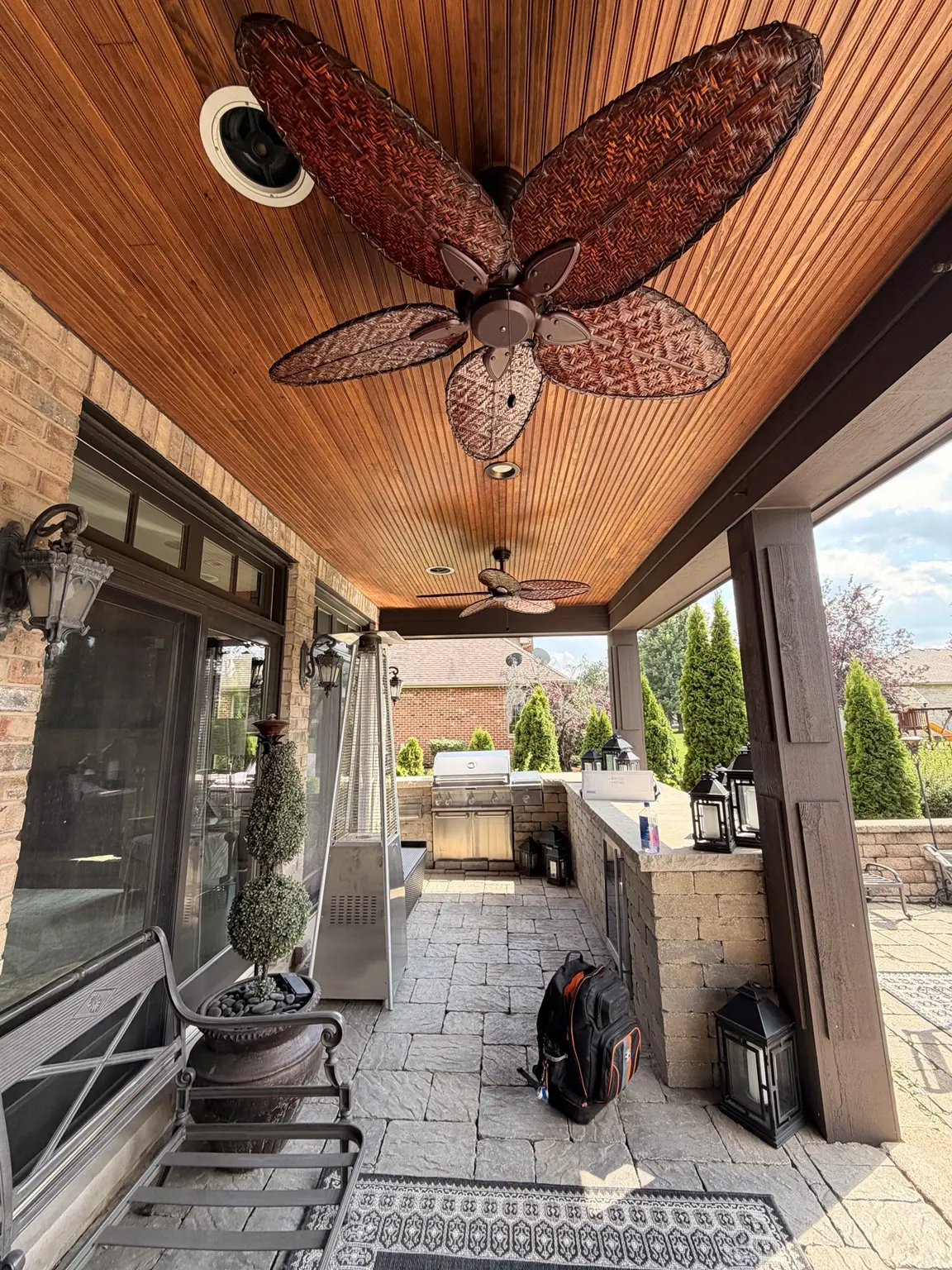 Two decorative ceiling fans installed on a covered outdoor patio